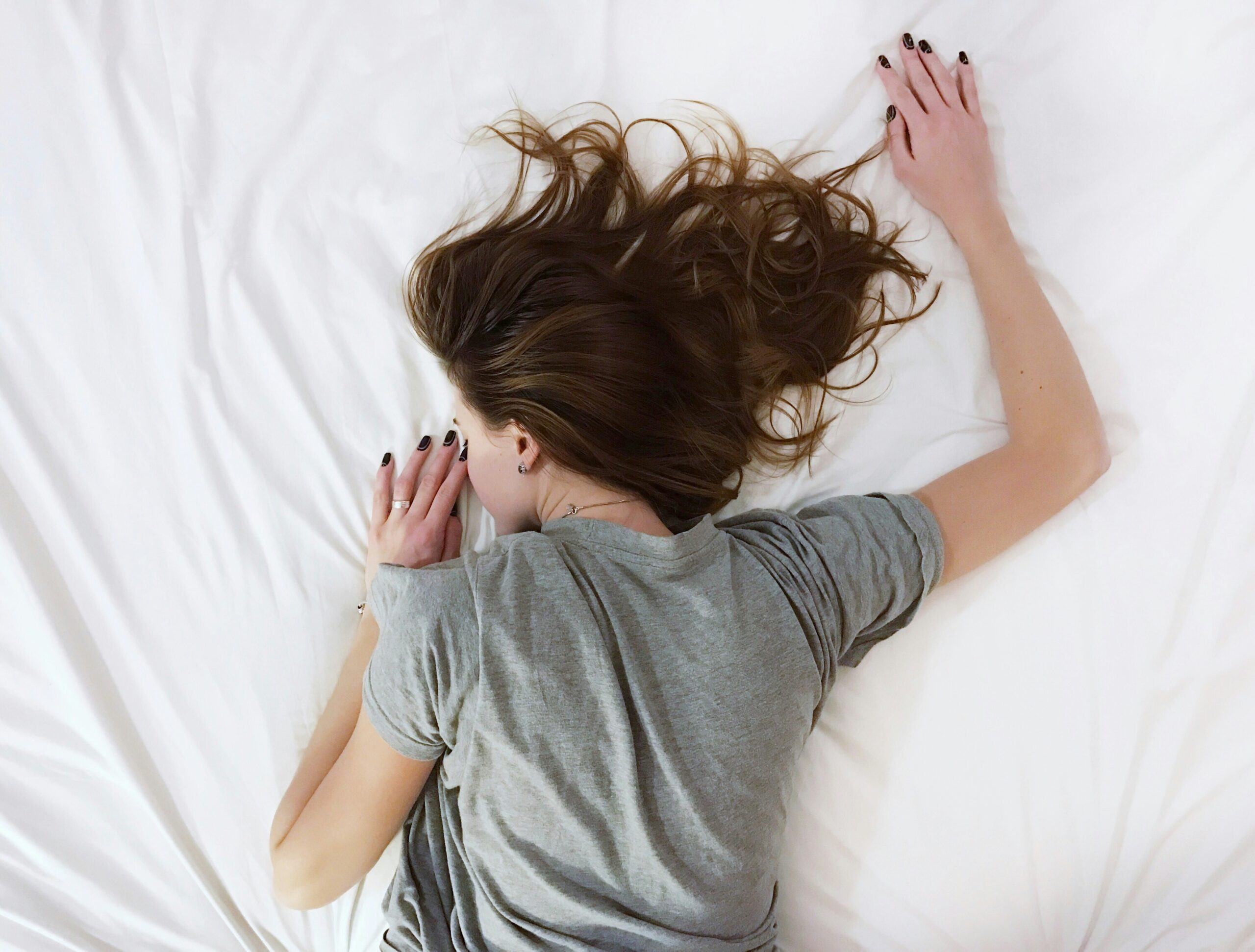 ベッドに突っ伏して疲れている女性